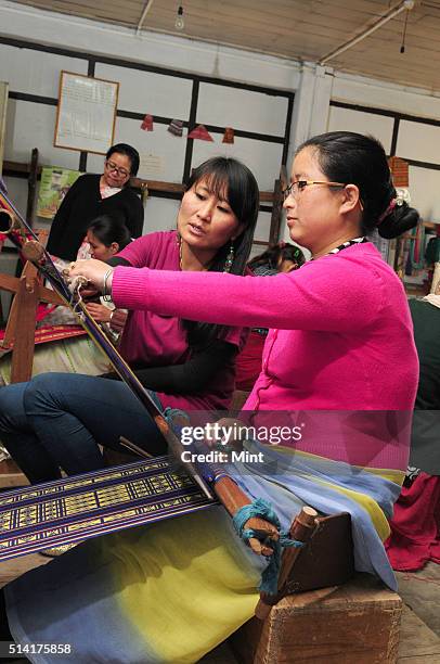 Karma Sonam with a weaver working on handloom at the directorate of Handicraft and Handloom office on March 11, 2015 in Gangtok, India. Karma Sonam...