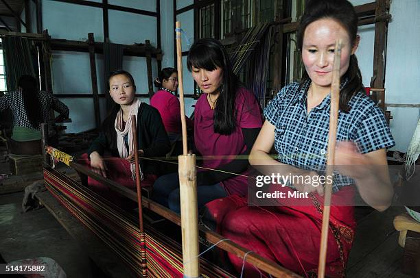 Textile designer Karma Sonam with a weaver working on handloom at the directorate of Handicraft and Handloom office on March 11, 2015 in Gangtok,...