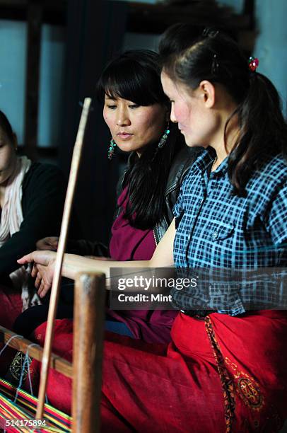 Textile designer Karma Sonam with a weaver working on handloom at the directorate of Handicraft and Handloom office on March 11, 2015 in Gangtok,...