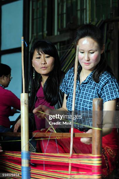 Textile designer Karma Sonam with a weaver working on handloom at the directorate of Handicraft and Handloom office on March 11, 2015 in Gangtok,...