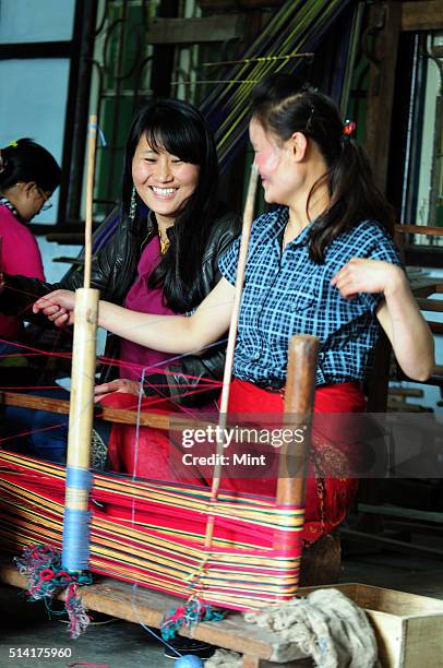 Textile designer Karma Sonam with a weaver working on handloom at the directorate of Handicraft and Handloom office on March 11, 2015 in Gangtok,...