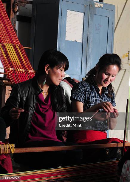 Textile designer Karma Sonam with a weaver working on handloom at the directorate of Handicraft and Handloom office on March 11, 2015 in Gangtok,...