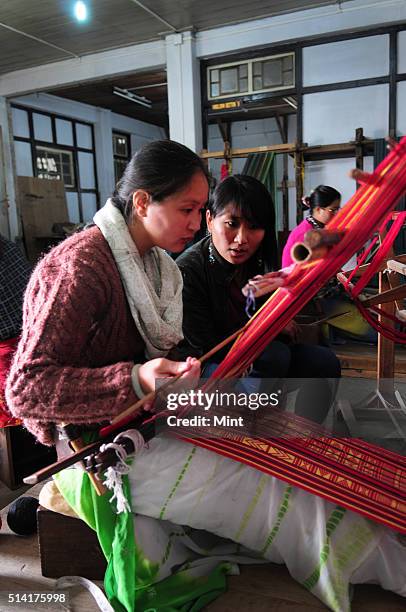 Textile designer Karma Sonam with a weaver working on handloom at the directorate of Handicraft and Handloom office on March 11, 2015 in Gangtok,...