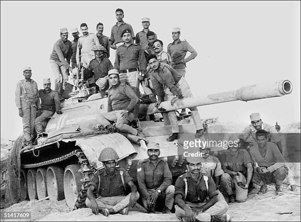 Indian army officers and soldiers stand 11 December 1971 atop a captured Pakistani tank in the desert of the state of Rajasthan during the...