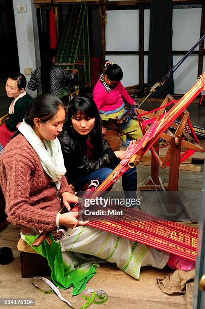 Karma Sonam with a weaver working on handloom at the directorate of Handicraft and Handloom office on March 11, 2015 in Gangtok, India. Karma Sonam...