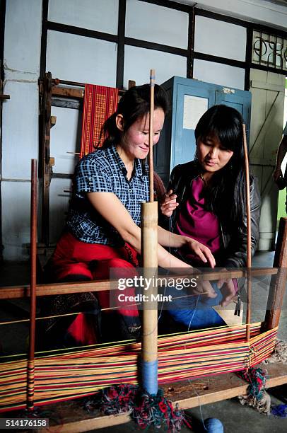 Karma Sonam with a weaver working on handloom at the directorate of Handicraft and Handloom office on March 11, 2015 in Gangtok, India. Karma Sonam...