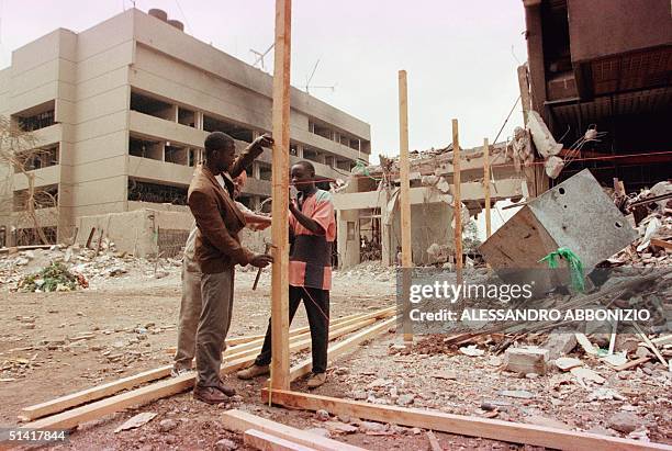 Construction workers prepare to fence off damaged shops and offices 17 August at the scene of a bomb blast that killed 247 people in Nairobi last...