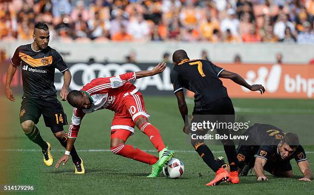 Teal Bunbury of New England Revolution attempts to maintain control of the ball as dribbles between DaMarcus Beasley of Houston Dynamo, Alex and Will...