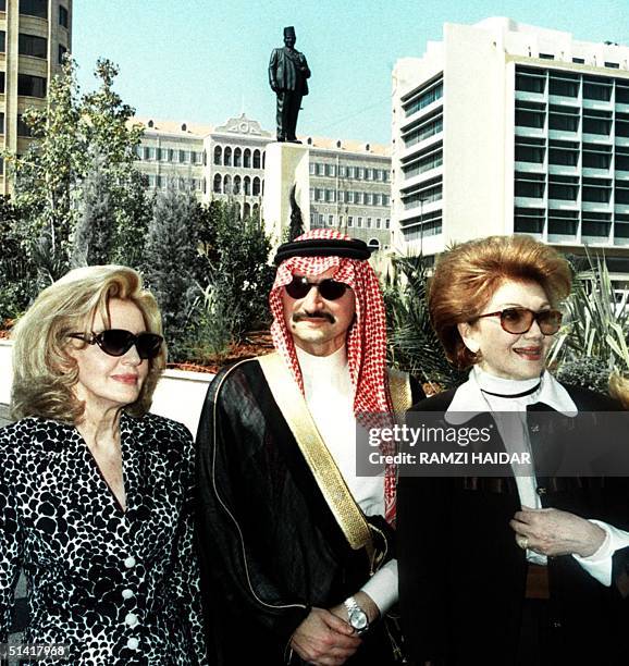 Saudi tycoon Prince al-Waleed Bin Talal stands 14 October between his Lebanese mother Mona and his aunt Bahija at the feet of the statue of his late...