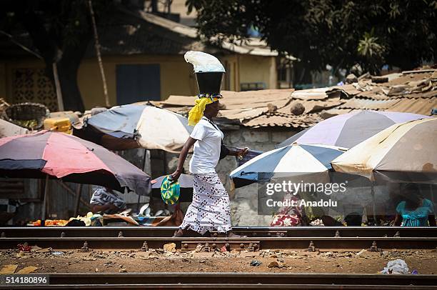 Guinean woman carries a bucket on her head as she walks in Conakry, Guinea on March 7, 2016. Guinean women give their children to foreigners who...
