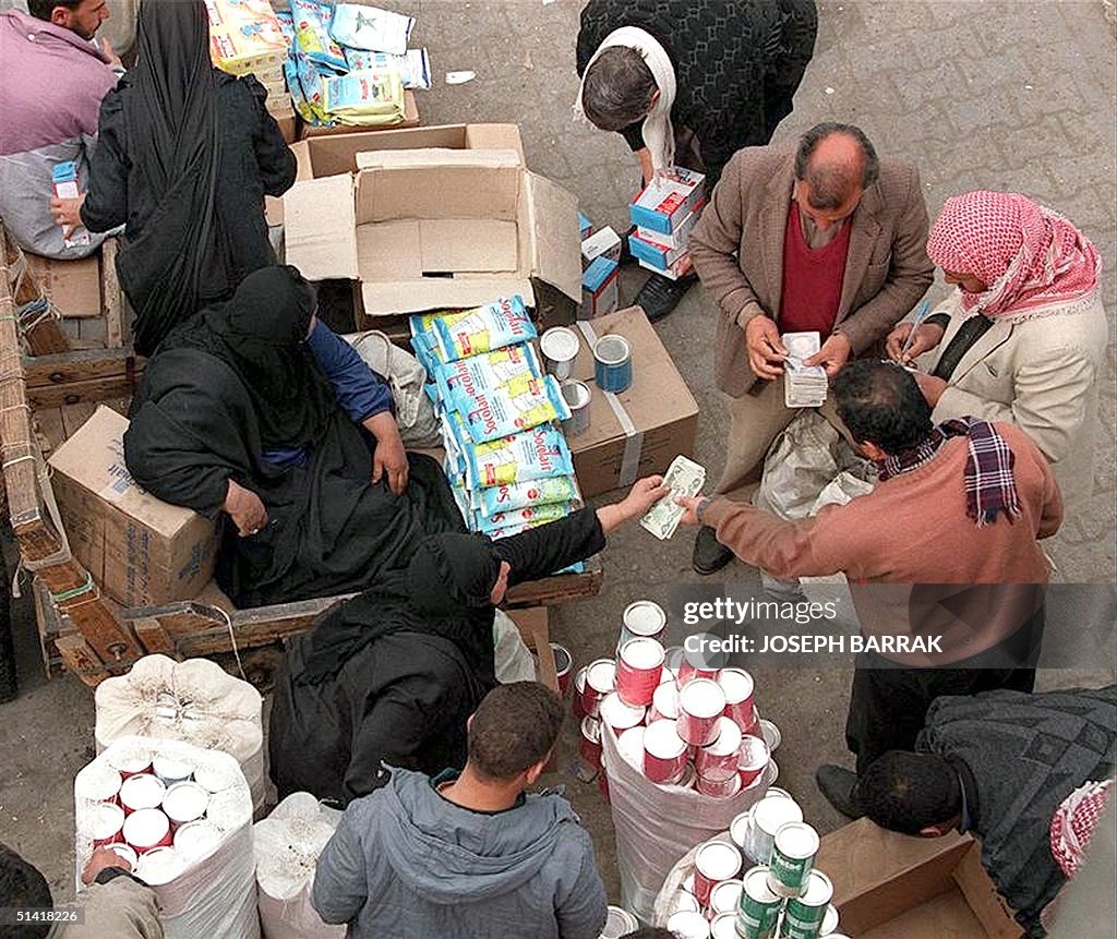 Iraqis buy smuggled goods from a street vendor in