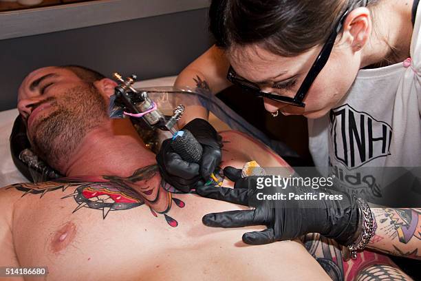 Female tattoo artist doing body art a the third edition of the Female Artists Tattoo Convention 2016 in Rome, called "The other side of the ink" was...