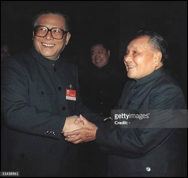 Chinese paramount leader Deng Xiaping shaking hands with Chinese President Jiang Zemin at the end of the 14th Party Congress in Beijing October 1992....