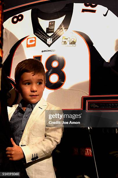 Denver Broncos quarterback Peyton Manning's 4 year old son Marshall hangs onto daddy's leg after a press conference to announce his retirement from...
