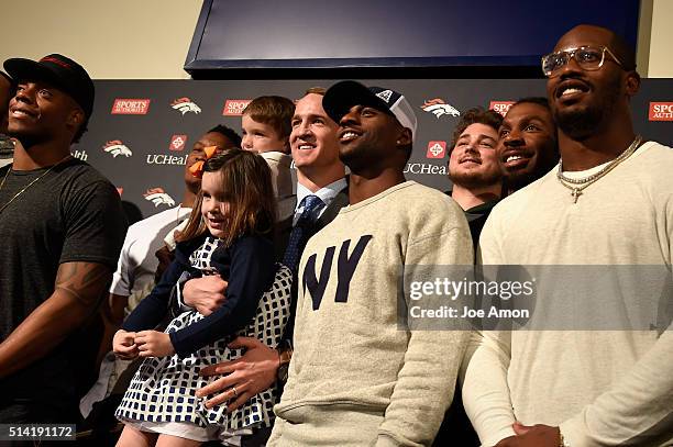 Denver Broncos quarterback Peyton Manning's 4 year old twins Mosley and Marshall join the group for a picture of former and present players after a...