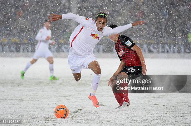 Yussuf Poulsen of RB Leipzig is challenged by Marc-Oliver Kempf of Freiburg during the Second Bundesliga match between SC Freiburg and RB Leipzig at...