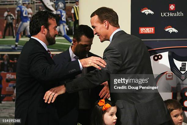 Quarterback Peyton Manning greets former teammates Jeff Saturday and Brandon Stokley after announcing his retirement from the NFL at the UCHealth...