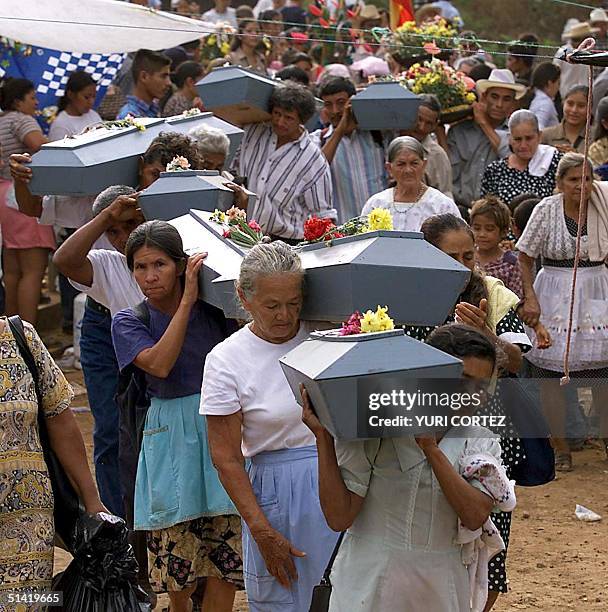 Women farmers carry the remains of their murdered family members in El Mozote, El Salvador 08 December 2001. Mujeres campesinas cargan ataudes con...