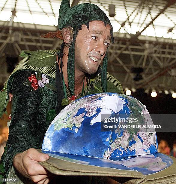 An activist is seen demonstrating a "new world" in Porto Alegre, Brazil 05 February 2002. Un activista ecologico disfrazado de selva muestra un...