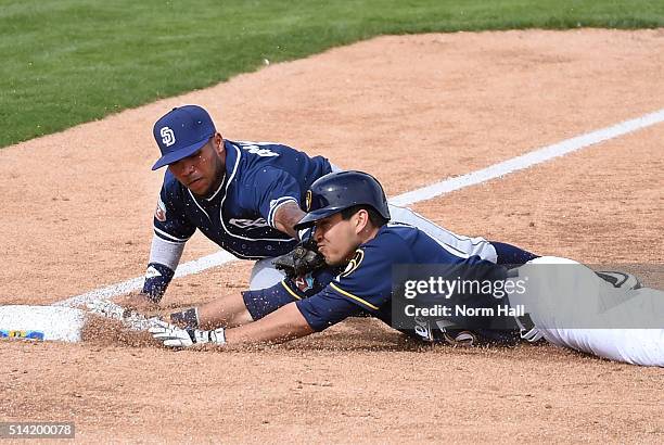 Alexi Amarista of the San Diego Padres tags out Ramon Flores of the Milwaukee Brewers at third base during the third inning of a spring training game...