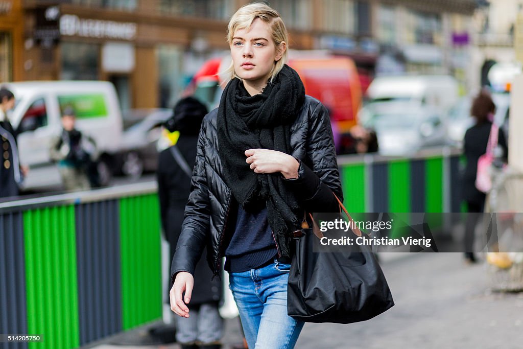 A model with a black feather down jacket and Longchamp bag outside