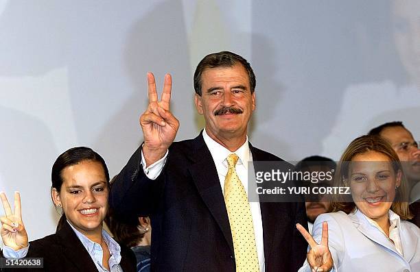 Vicente Fox, the new Mexican president-elect, accompanied by his daughters Pauline and Cristina , makes the victory sign during a press conference in...