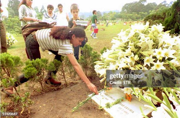 An unidentified woman places flowers on the grave of slained Medellin drug cartel boss Pablo Escobar 30 Nov at a local cemetery in Medellin. Escobar...