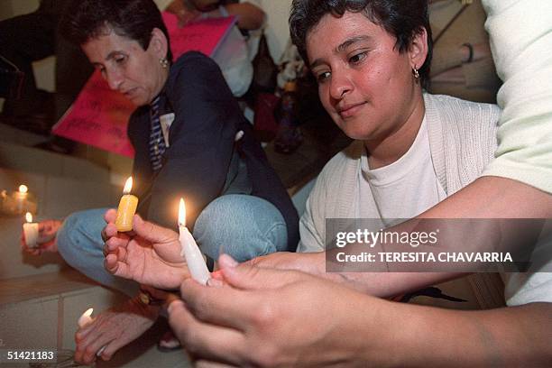 Member of the Delegation of Women lights candles during a vigil that took place, 01 November 2000, in one of the rooms in the Legislative Assembly in...