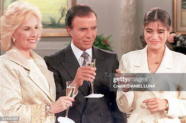 Argetine President Carlos Menem toast with his daughter Zulemita and TV host Mirta Legrand 11 May during a live TV show in Buenos Aires three days...