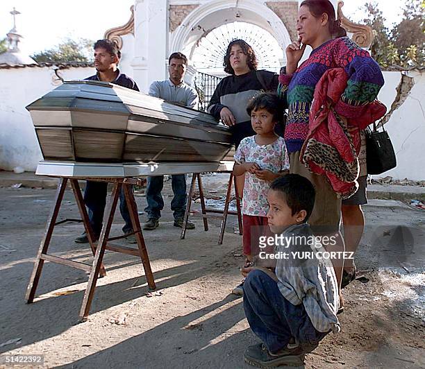 Salvadoran family in Santa Tecla, El Salvador stands by the casket, 15 January 2001, of a loved one who died when an earthquake rocked Central...