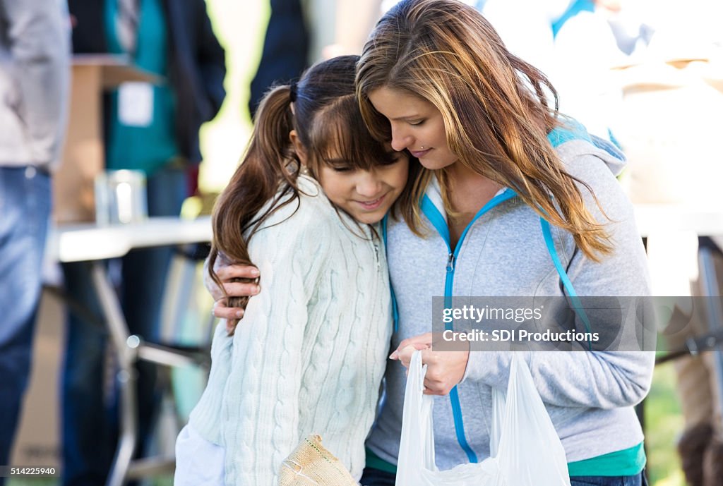 Woman comforts daughter at clothing drive