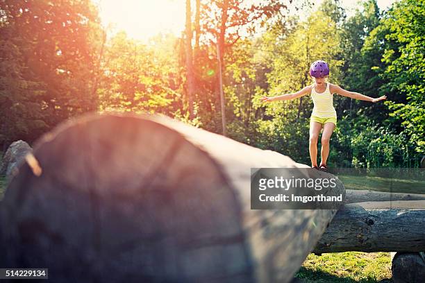 little girl balancing on a trunk in adventure park - obstacle course stock pictures, royalty-free photos & images