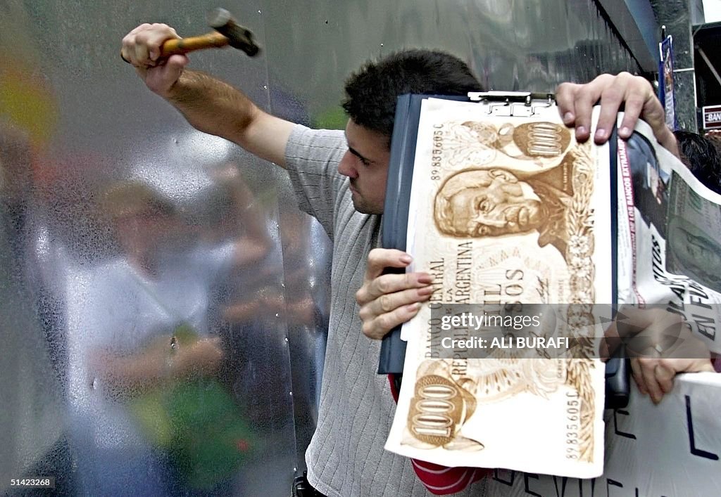 Argentinians try to break down a metal wall at a b