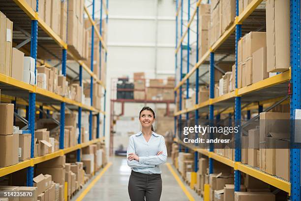 thoughtful business woman at a warehouse - dream deliveries stockfoto's en -beelden