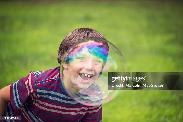 boy laughing and looking through large bubble - bubble wand stock pictures, royalty-free photos & images