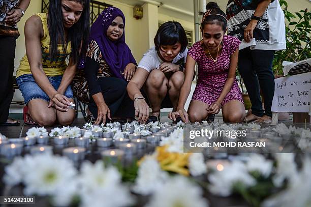 School teachers put candles on the floor to pay tribute to passengers of missing Malaysia Airlines flight MH370 in Petaling Jaya on March 8, 2016....