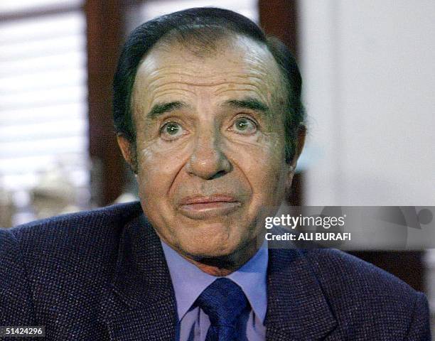 Former president of Argentina, Carlos Menem, talks with supporters in the governor's residence in the province of Rioja, 25 July 2002 . New...