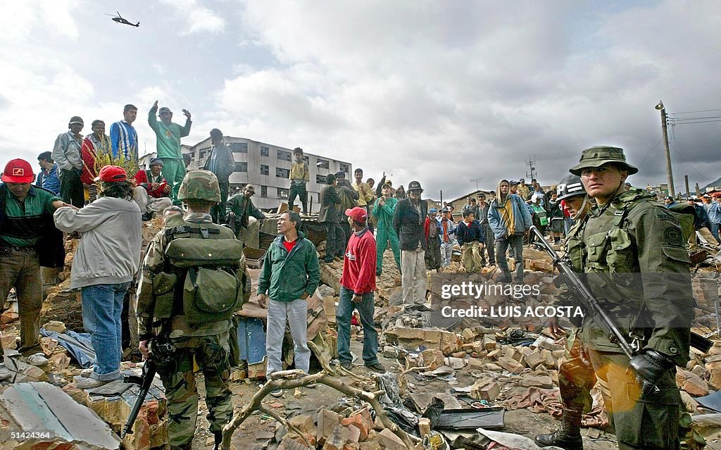 Soldiers and relief workers stand amid destruction