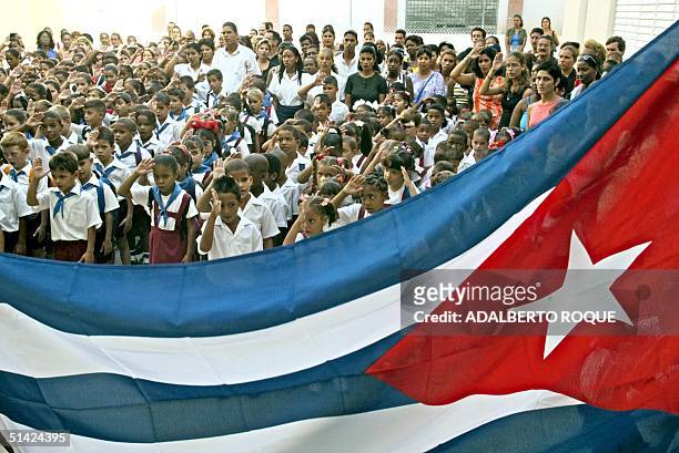 Cuban school children salute the national flag 03 September 2002 at the "Juramento de Baragua" elementary school in La Habana. This particular school...