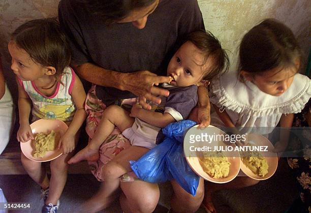 Olga Yanira is fed by her mother thanks to a program created to fight hunger in Orcuina, Honduras 05 October 2002. Olga Yanira es alimentada por su...