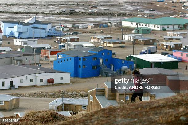 Young native girl runs on a hill overlooking the village of Iqaluit, Nunavut, Canada 05 October, 2002. Britain's Queen Elizabeth II and her husband,...