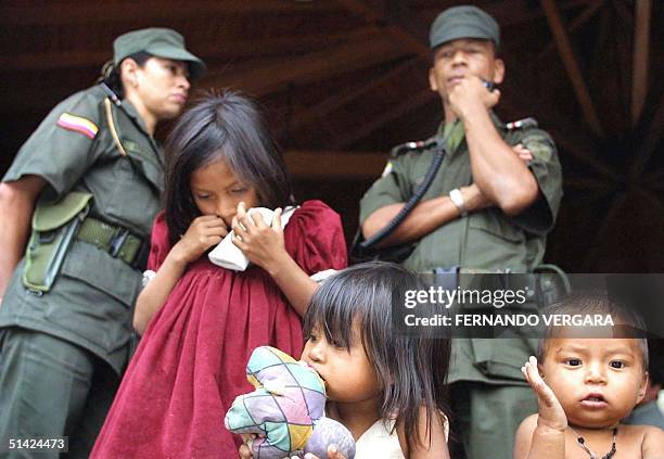 Three indigenous children belonging to the "Embera Chamo" tribe wait to be moved, 07 October 2002, by Police agents of Medellin, Colombia. More than...