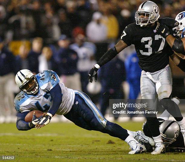 Skip Hicks of the Tennessee Titans runs the ball past Johnnie Harris of the Oakland Raiders at Network Associates Coliseum in Oakland, California ....