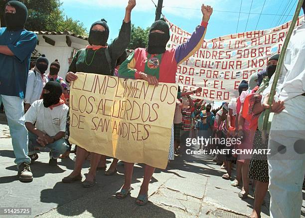 Two women wave a sign to reclaim the fulfillment of the Accords of San Andres, 08 March during a demonstration in Chiapas, Mexico. Dos mujeres llevan...