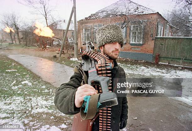 Chechen fighter carrying a machine gun heads for Grozny city center 17 January as fierce fighting with Russian soldiers continue in the break-away...