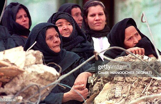 Women watch rescue teams searching the debris of houses in the Zabbalin suburb of Cairo, Egypt, 14 December 1993, after a landslide sent boulders...