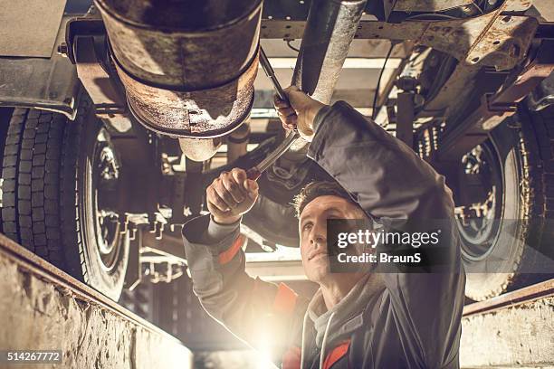 male mechanic using socket wrench while working on chassis. - socket wrench stock pictures, royalty-free photos & images