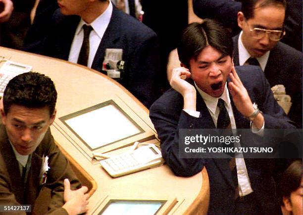 Stock traders yawns during a slow morning session of trading at the Tokyo Stock Exchange 11 April 1994. In light trading, the Nikkei Stock Average...