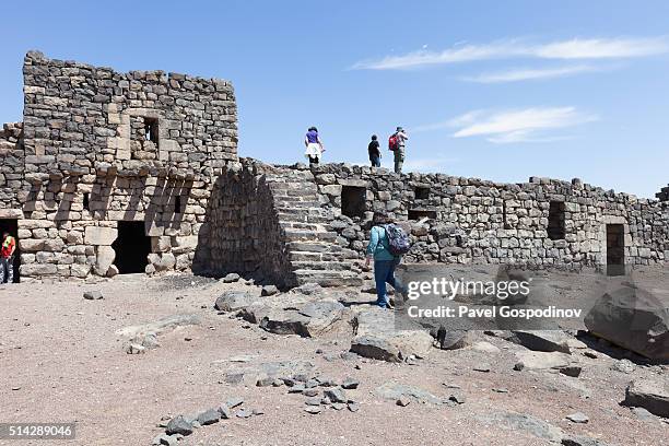 tourist enjoying the desert castle qasr al-azraq in jordan - qasr al azraq stock pictures, royalty-free photos & images