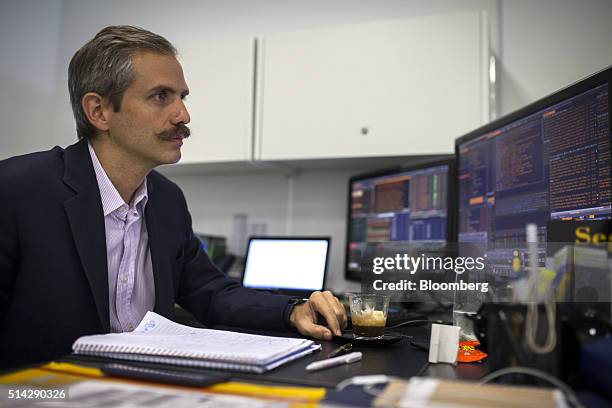 Carmelo Haddad, managing director of Knossos Asset Management, views a computer screen during an interview in the company's offices in Caracas,...